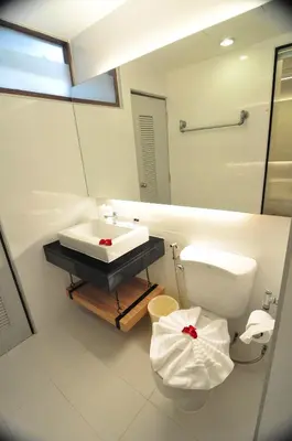 a bathroom with a sink and a toilet and a mirror at Forty Winks Phuket Hotel in Patong Beach