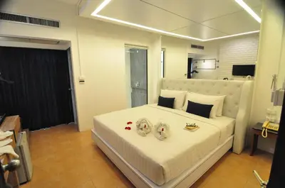 a bedroom with a large white bed with two engagement rings at Forty Winks Phuket Hotel in Patong Beach