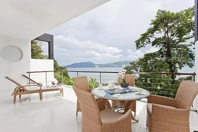a patio with a table and chairs on a balcony at Atika Villas in Patong Beach