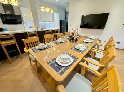a dining room table with plates and glasses on it at Naka Central Happy Home in Phuket city in Ban Rangeng