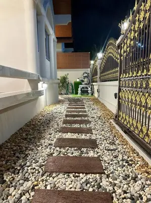 a stone walkway in front of a house at night at Naka Central Happy Home in Phuket city in Ban Rangeng