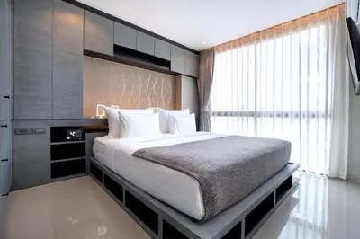 a bedroom with a large bed and a window at Urban Suite CTG B702 in a Gated Tropics Kamala Residence with 3 Pools & Gym in Kamala Beach