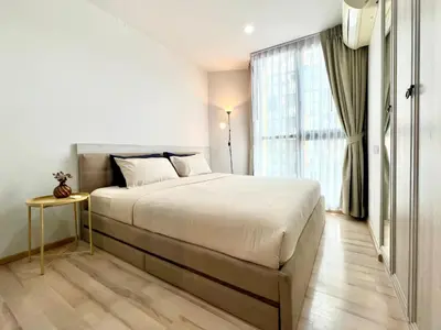 a bedroom with a bed and a large window at 1BR Apartment with Rooftop Pool - The Base Height Phuket town in Ban Sam Kong