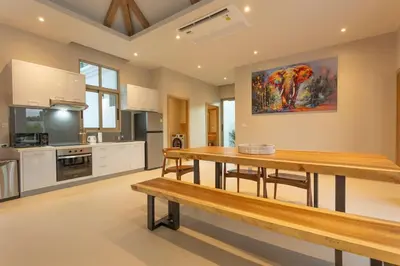 a kitchen with a wooden table in a room at Brand New Completed v124 in Chalong