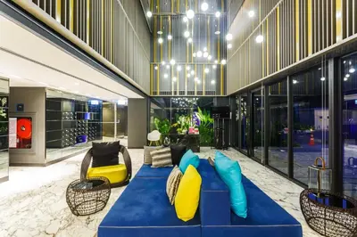 a living room with a blue couch and yellow pillows at Deck Condo private apartment by Lofty in Patong Beach