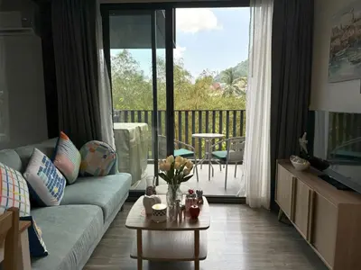 a living room with a couch and a table at Deck Condo private apartment by Lofty in Patong Beach