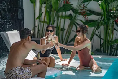 a group of people sitting in a swimming pool drinking champagne at Luxury Pool Villa in Nai Harn - Villa Solana in Rawai Beach