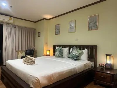 a bedroom with a large bed and a chair at Patong Tower Dream Sea View Apartment in Patong Beach