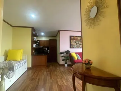 a living room with a table and yellow walls at Patong Tower Dream Sea View Apartment in Patong Beach