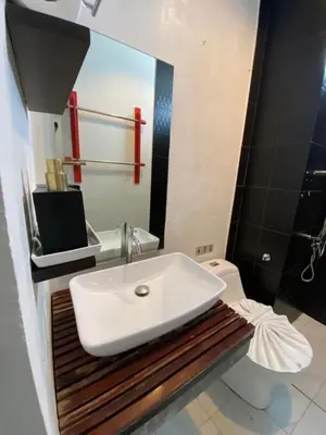 a bathroom with a white sink and a toilet at By the Sea Apartment Hotel in Krabi town