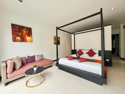 a bedroom with a bed and a couch at Garden 2 bedrooms pool villa in Laguna Phuket