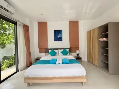 a bedroom with a large bed with blue pillows at Garden 2 bedrooms pool villa in Laguna Phuket