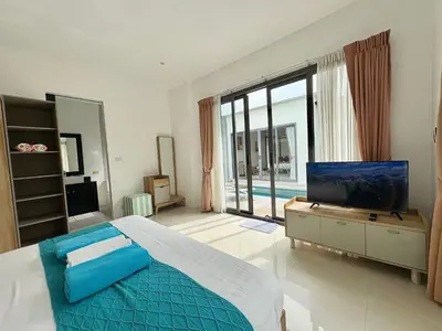 a bedroom with a large bed and a large window at Garden 2 bedrooms pool villa in Laguna Phuket