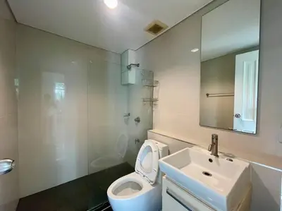 a bathroom with a toilet and a sink and a mirror at Kamala Regent Condo in Kamala Beach