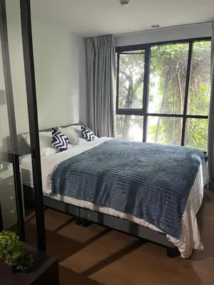 a bedroom with a bed and a large window at Centrio room in Ban Rangeng