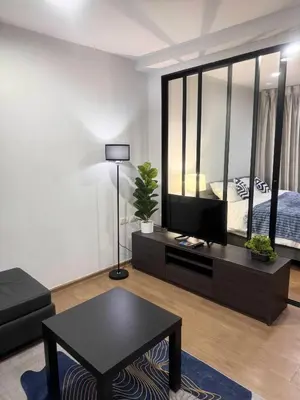 a living room with a black table and a large mirror at Centrio room in Ban Rangeng