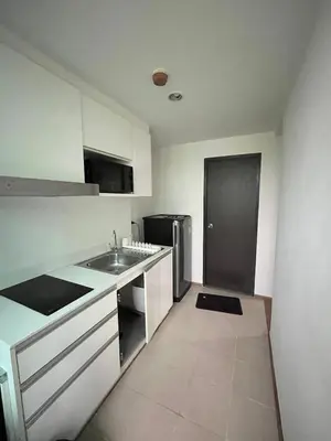 a small kitchen with a sink and a refrigerator at Centrio room in Ban Rangeng
