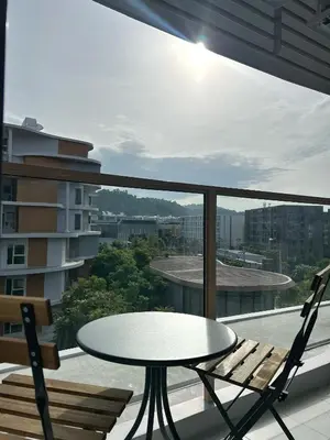 a table and two chairs on a balcony with a table at PHYLL Condo Private Beach Vibes at Central Phuket 1 BR Unique Garden View in Ban Rangeng