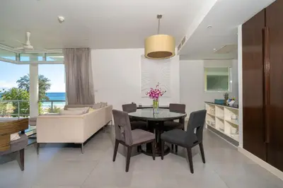 a kitchen and dining room with a table and chairs at Karon Beachfront Apartment 724 in Karon Beach