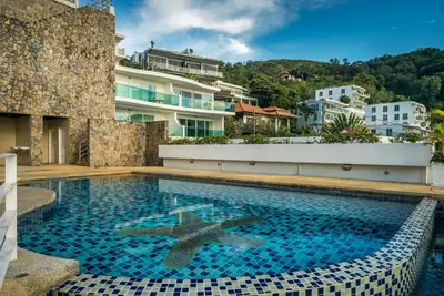 a swimming pool in front of a building at Sea view Kata apartment near Santosa SPA D5 in Kata Beach