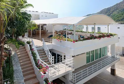 a building with a balcony with flowers on it at Sea view Kata apartment near Santosa SPA D5 in Kata Beach