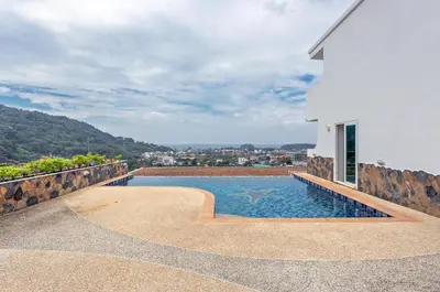 a swimming pool on the side of a house at Sea view Kata apartment near Santosa SPA D5 in Kata Beach