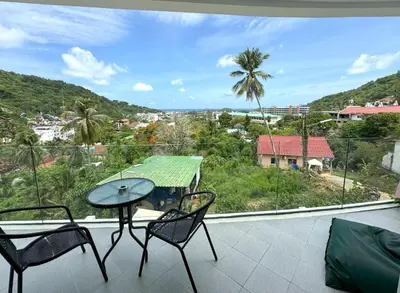 a balcony with a table and chairs and a view at Sea view Kata apartment near Santosa SPA D5 in Kata Beach