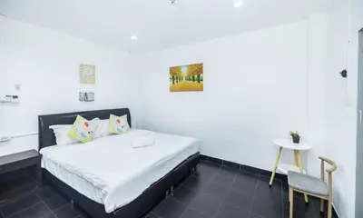 a bedroom with a bed and a table and a chair at Belle Cose Guest House Phuket in Patong Beach
