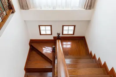 a staircase in a house with two windows at Chalong V pool villa in Ban Klang