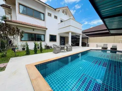 a swimming pool in front of a house at Chalong V pool villa in Ban Klang