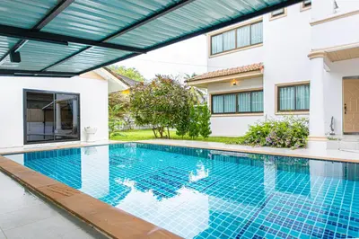 a swimming pool in front of a house at Chalong V pool villa in Ban Klang