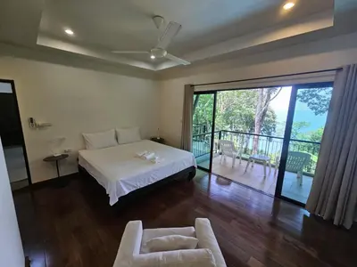 a bedroom with a bed and a balcony at Beachfront villa in Rawai in Phuket Town