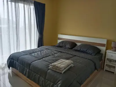 a bedroom with a large bed with a large window at Yellow house in Ban Saiyuan (1)