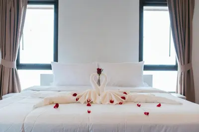 a woman in a dress on a bed with roses at San pool villa in Patong Beach
