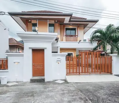 a white house with a gate and a fence at San pool villa in Patong Beach