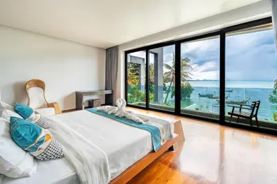 a bedroom with a bed and a view of the ocean at \u62c9\u5a01Eva8 \u4e09\u5367\u6d77\u8fb9\u522b\u5885 \u8fd1\u62c9\u5a01\u6d77\u9c9c\u5e02\u573a in Ban Saiyuan (1)