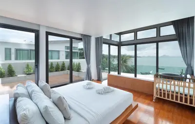 a bedroom with a white bed and large windows at \u62c9\u5a01Eva8 \u4e09\u5367\u6d77\u8fb9\u522b\u5885 \u8fd1\u62c9\u5a01\u6d77\u9c9c\u5e02\u573a in Ban Saiyuan (1)