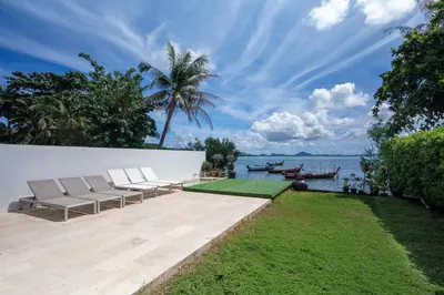 a patio with chairs and a view of the water at \u62c9\u5a01Eva8 \u4e09\u5367\u6d77\u8fb9\u522b\u5885 \u8fd1\u62c9\u5a01\u6d77\u9c9c\u5e02\u573a in Ban Saiyuan (1)