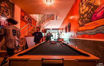two men standing in a room with a pool table at DANK Hotel 420 friendly Patong Phuket in Patong Beach
