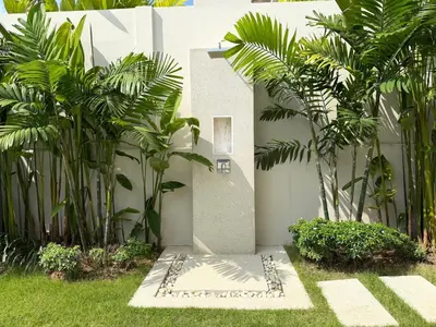 a garden with palm trees next to a building at Luxury 3BR Pool Villa near Blue Tree - Bang Tao in Amphoe Kathu