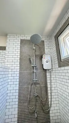 a shower in a tiled bathroom with a shower head at Picha house Kohyaonoi in Ban Laem Sai