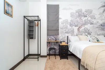 a bedroom with a bed and a wall mural at Mitsu Guesthouse in Karon Beach
