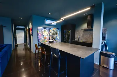 a kitchen with blue walls and a bar with stools at Tri Trang Beachfront Apartments with Stunning Views in Patong Beach