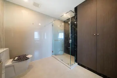 a bathroom with a glass shower and a toilet at Surin sea view 3br apartment with jacuzzi in Surin Beach