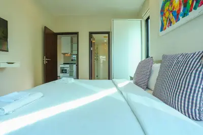 a large white bed in a room with a window at C251 Beachfront gym Sauna 7 Swimming Pool in Rawai Beach