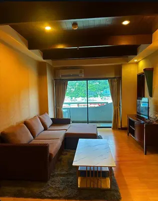 a living room with a couch and a table at Patong Tower Near Beach in Patong Beach