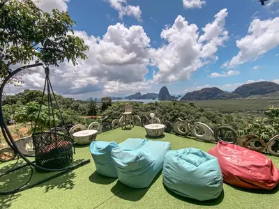 a group of chairs on the grass with mountains in the background at Samet Nangshe Goodview in Ban Met Nang Chi
