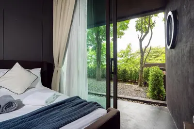 a bedroom with a bed and a large window at Spacious Pool Access Apartment with 2 BR - Rawai in Ban Saiyuan (1)
