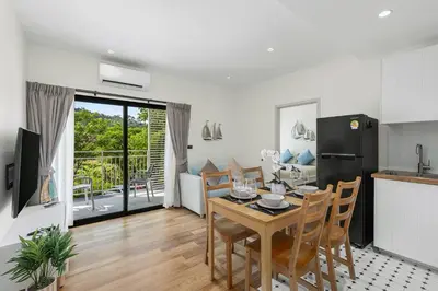 a kitchen and dining room with a table and chairs at The Title Halo NaiYang by My Home Phuket in Nai Yang Beach
