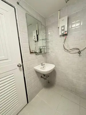 a white bathroom with a sink and a mirror at La Casa Patong in Patong Beach